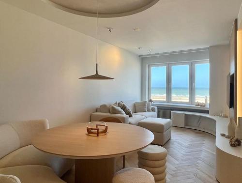 a living room with a table and a couch at Luxe appartement met adembenemend uitzicht op zee in Ostend