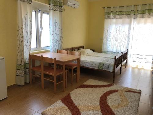 a bedroom with a bed and a table and chairs at Apartments Delcheva in Utjeha