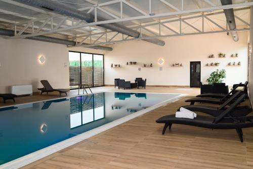 a pool room with chairs and a swimming pool at Boutique Hotel Ukus in Tešanj
