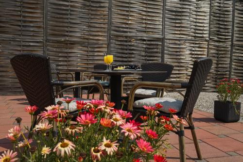 a patio with a table and chairs and flowers at Boutique Hotel Ukus in Tešanj
