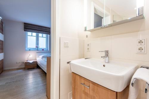 1 dormitorio y baño con lavabo blanco. en Haus Nordmarkgarten Whg 1, en Westerland