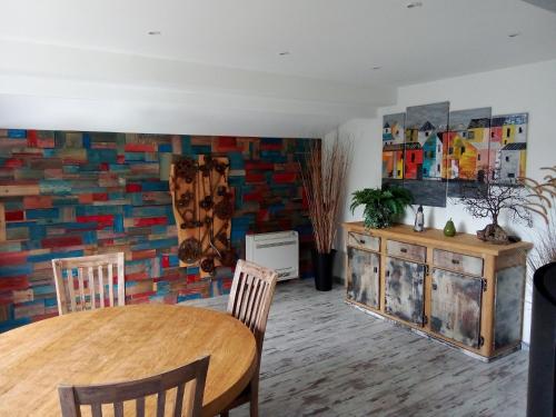 a dining room with a table and a brick wall at Chalet familial à la montagne in Caille