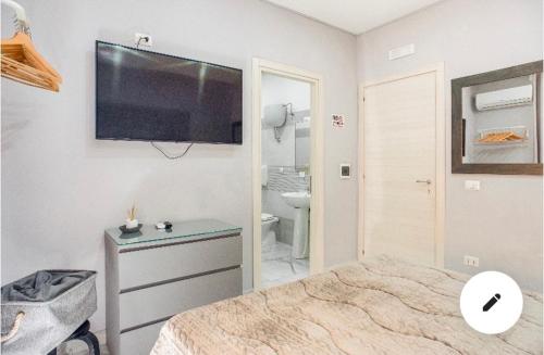 1 dormitorio con 1 cama y TV en la pared en B&B Alla Stazione, en Nápoles