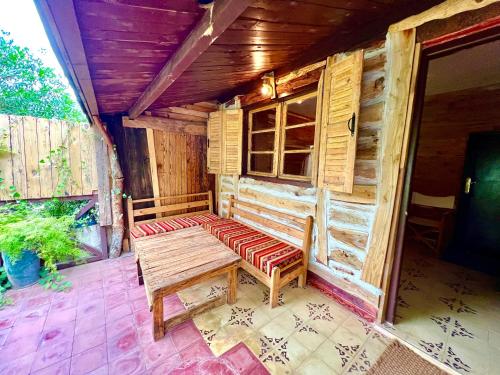 a wooden bench sitting on the porch of a cabin at Dar l'eau Vive in Bine el Ouidane