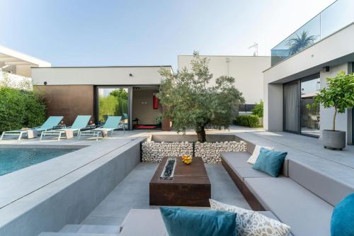 een woonkamer buiten met een zwembad en een patio bij Villa Marli ZadarVillas in Zaton