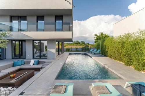 een zwembad in de achtertuin van een huis bij Villa Marli ZadarVillas in Zaton