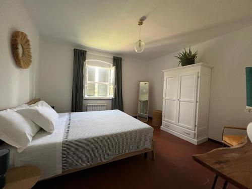 sypialnia z łóżkiem i białą szafką w obiekcie AceroRosso Farmhouse w mieście Sarzana