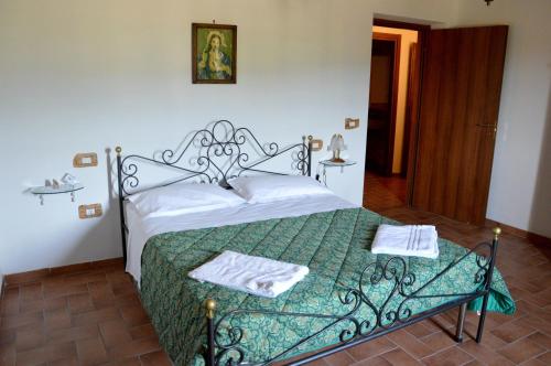 マッサ・マルターナにあるAgriturismo La Collinaのベッドルーム1室(ベッド1台、緑の掛け布団付)