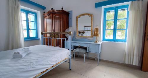1 dormitorio con cama, tocador y espejo en Αρχοντικό ΑΤΤΙΚ - ATTIK MANSION, en Livadi
