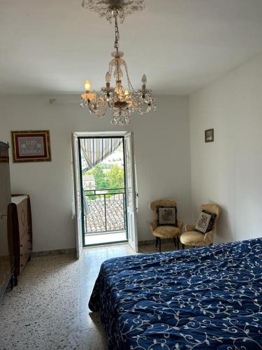 Un dormitorio con una cama azul y una lámpara de araña. en Relax in Sicily, en Alimena