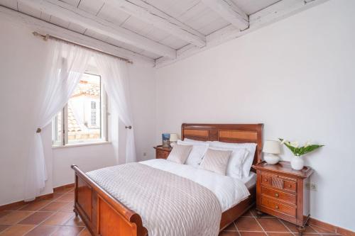 ein Schlafzimmer mit einem großen Bett und einem Fenster in der Unterkunft FORTUNATA Apartment in Dubrovnik