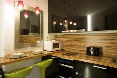 a kitchen with a counter with a microwave and green chairs at City Center Apartment in Barcelona