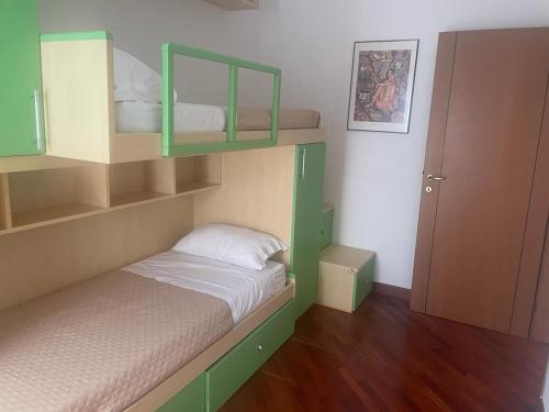 a small bedroom with a bunk bed with green shelves at Casa Antonella in Rome