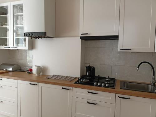 a kitchen with white cabinets and a counter top at -WYPOCZYNKOWY- in Sopot