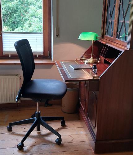 un escritorio con una silla y una lámpara. en Helles großes Zimmer mit eigenem Bad, en Kassel