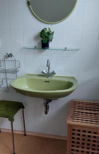 a green sink in a bathroom with a mirror at Helles großes Zimmer mit eigenem Bad in Kassel