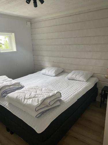 a bed with white sheets and towels on it at Mysig källarlägenhet i Lindvallen in Sälen