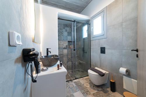 uma casa de banho com um chuveiro, um WC e um lavatório. em Falakis Apartments em Kythnos