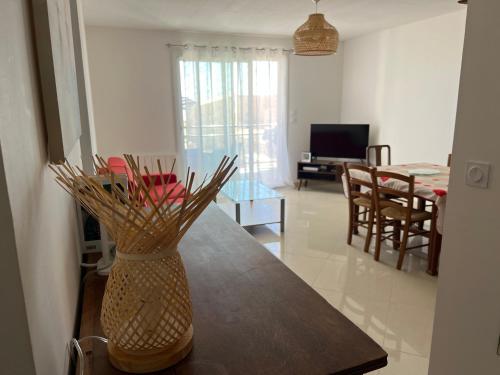 un vase assis sur une table dans un salon dans l'établissement Superbe appartement à Saint Pierre la Mer, à Saint Pierre La Mer