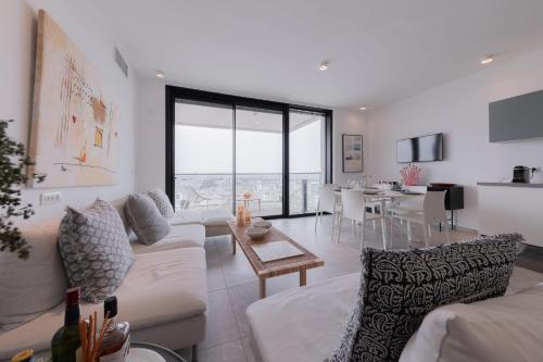 Neve Tzedek Apartment-Hosted by Sweetstay في تل أبيب: غرفة معيشة مع كنب ابيض وطاولة