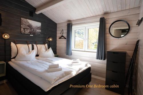 a bedroom with a large bed with a window at Geirangerfjorden Feriesenter in Geiranger
