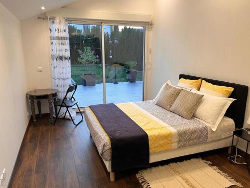 une chambre avec un lit, une table et une fenêtre dans l'établissement Logement moderne, dans mon jardin, près de Paris et stade de France avec place de stationnement, à Sannois