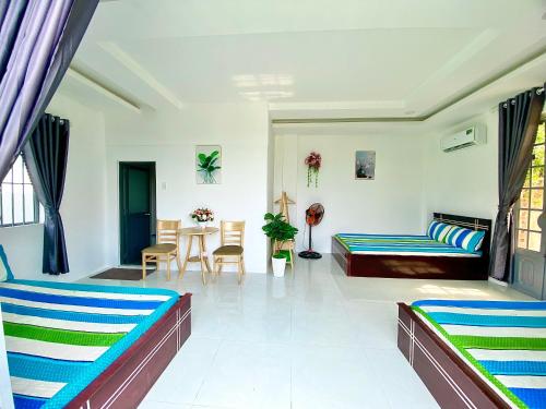 Sala de estar con 2 camas y mesa en Hotel Cù Lao 3, en Tây Ninh