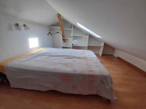 a white bedroom with a bed in a attic at Le Mialan t1 à la campagne à 10 minutes de Valence in Saint-Péray