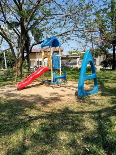 a playground with two slides in a yard at TMD COMFORTABLE TRANSIENT HOUSE IN STO.TOMAS BATANGAS (UNIT 1) in San Felix