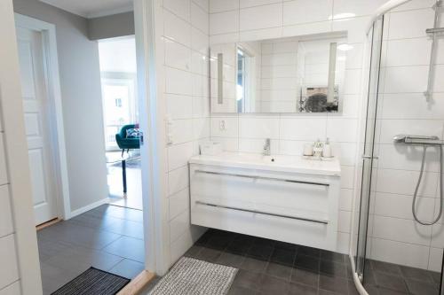 a white bathroom with a sink and a shower at Cozy and new apartment in Arendal -Hill in Arendal