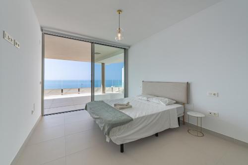 um quarto com uma cama e vista para o oceano em 3 Bedroom sea view Stupa Hills em Benalmádena