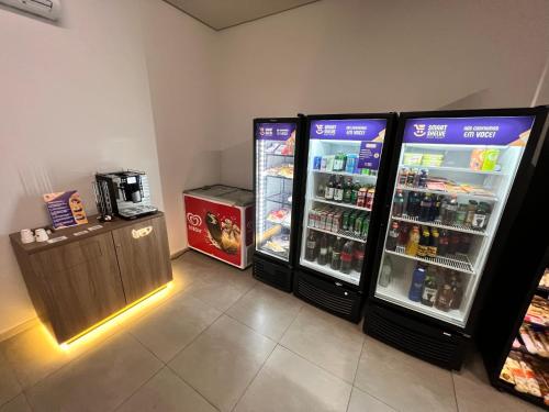 a room with two refrigerators and a drink cooler at Flat Completo Granja Brasil in Petrópolis