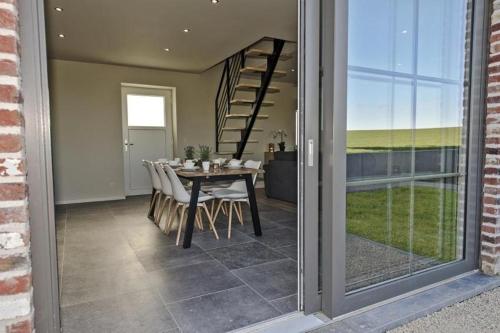 a dining room with a table and a glass door at Les Petits Sablens in Grandmetz