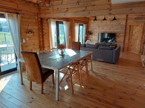 une salle à manger avec une table, des chaises et un canapé dans l'établissement chalet de la voie verte en plein coeur du Jura, à Montigny-sur-lʼAin