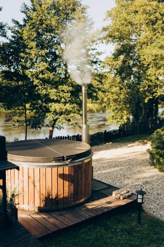 a hot tub with a smoke stack in a park at Osada Poli - Domek nad Narwią in Łachy