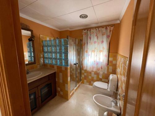 a bathroom with a toilet and a sink and a shower at VILLA en Playa La Barrosa in Chiclana de la Frontera