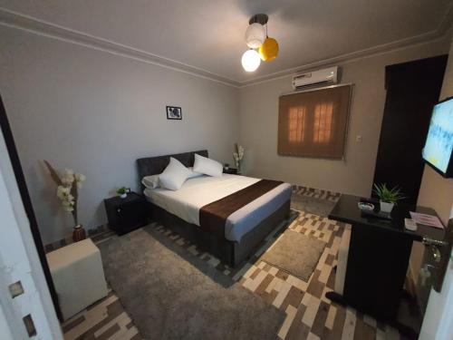 een slaapkamer met een bed en een televisie. bij Youvala serviced apartment Giza in Caïro