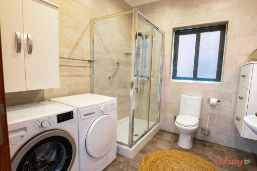 y baño con ducha y lavadora. en A pretty holiday home in Malta’s fishing village, en Marsaxlokk