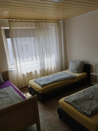 a bedroom with two beds and a window at worker-flat in Gelsenkirchen