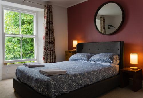 テンビーにあるManorbier House - Caldey Island Roomのベッドルーム1室(大型ベッド1台、壁に鏡付)