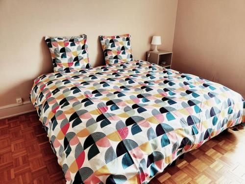 - une chambre avec un grand lit et une couette colorée dans l'établissement Superbe appartement lumineux avec vue imprenable, à Tours
