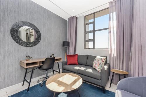 a living room with a couch and a table at The Median Rosebank Luxury Apartment - Building with Generator in Johannesburg