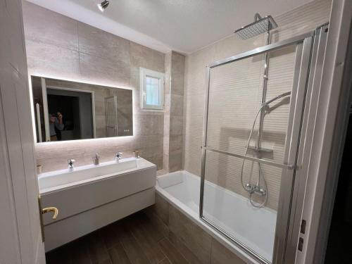 une salle de bain avec une douche, un lavabo et un miroir dans l'établissement Villa dans un puits de verdure avec piscine résidentielle, à Valbonne