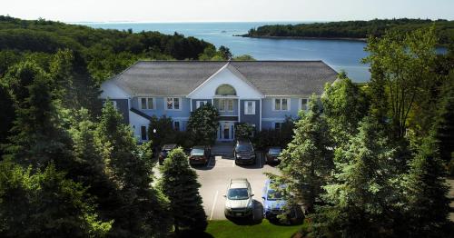 a large blue house with cars parked in a driveway at Strawberry Hill Seaside Inn in Rockport
