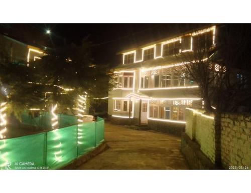 un edificio con luces encendidas por la noche en Hotel Prem Rose, Pahalgam, en Pahalgām