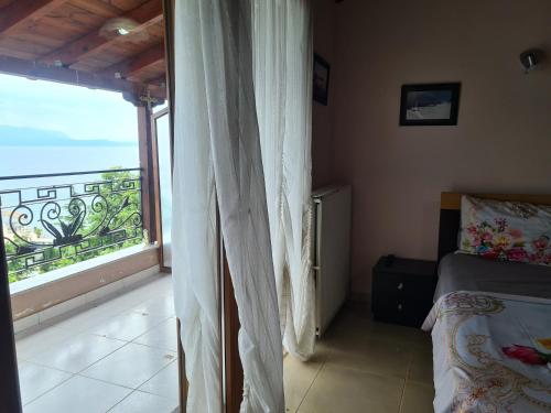 1 dormitorio con balcón con cama y ventana en Hotel Kukesi en Pogradec