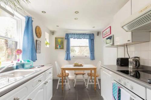 a kitchen with a sink and a table with chairs at Charming 3BD Flat - 5 Minutes to Victoria Park in London