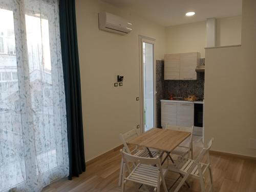 a kitchen with a table and chairs in a room at Butterfly Apartments in Palermo