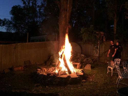 a fire pit in a yard with people standing around it at Riviera on Hawkesbury An island style escape in Bar Point