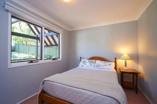 a bedroom with a bed and a window at Riviera on Hawkesbury An island style escape in Bar Point